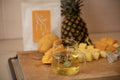 Tea cup with pineapple and mangoes on a wooden board