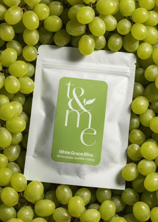 White Grape Bliss tea pouch on white grapes