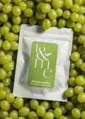 Small white pouch with green label on a bed of green grapes