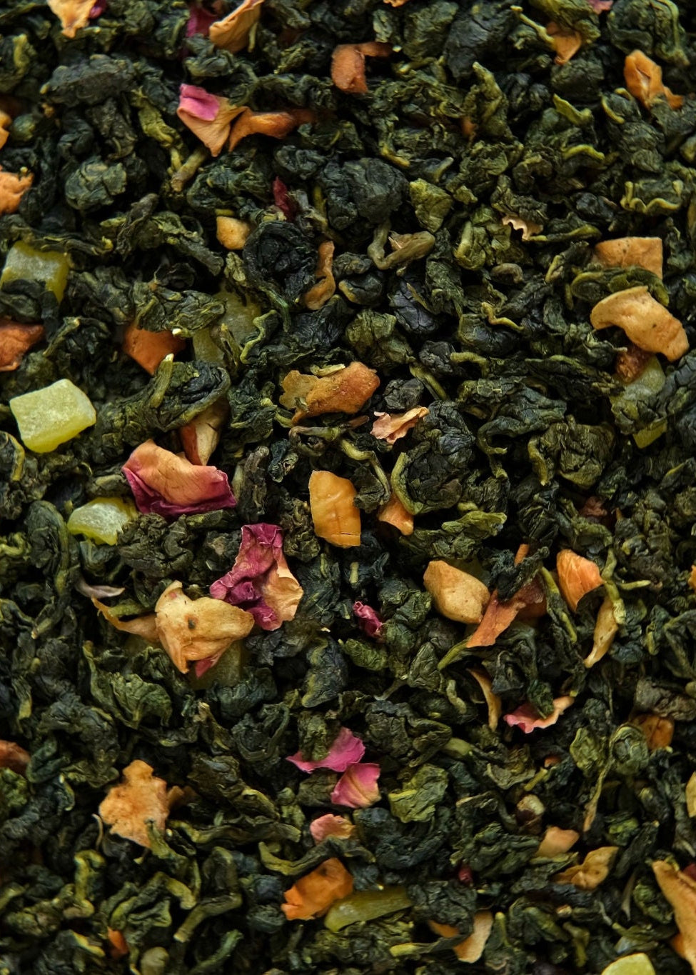 Close-up of green tea leaves with small colorful bits