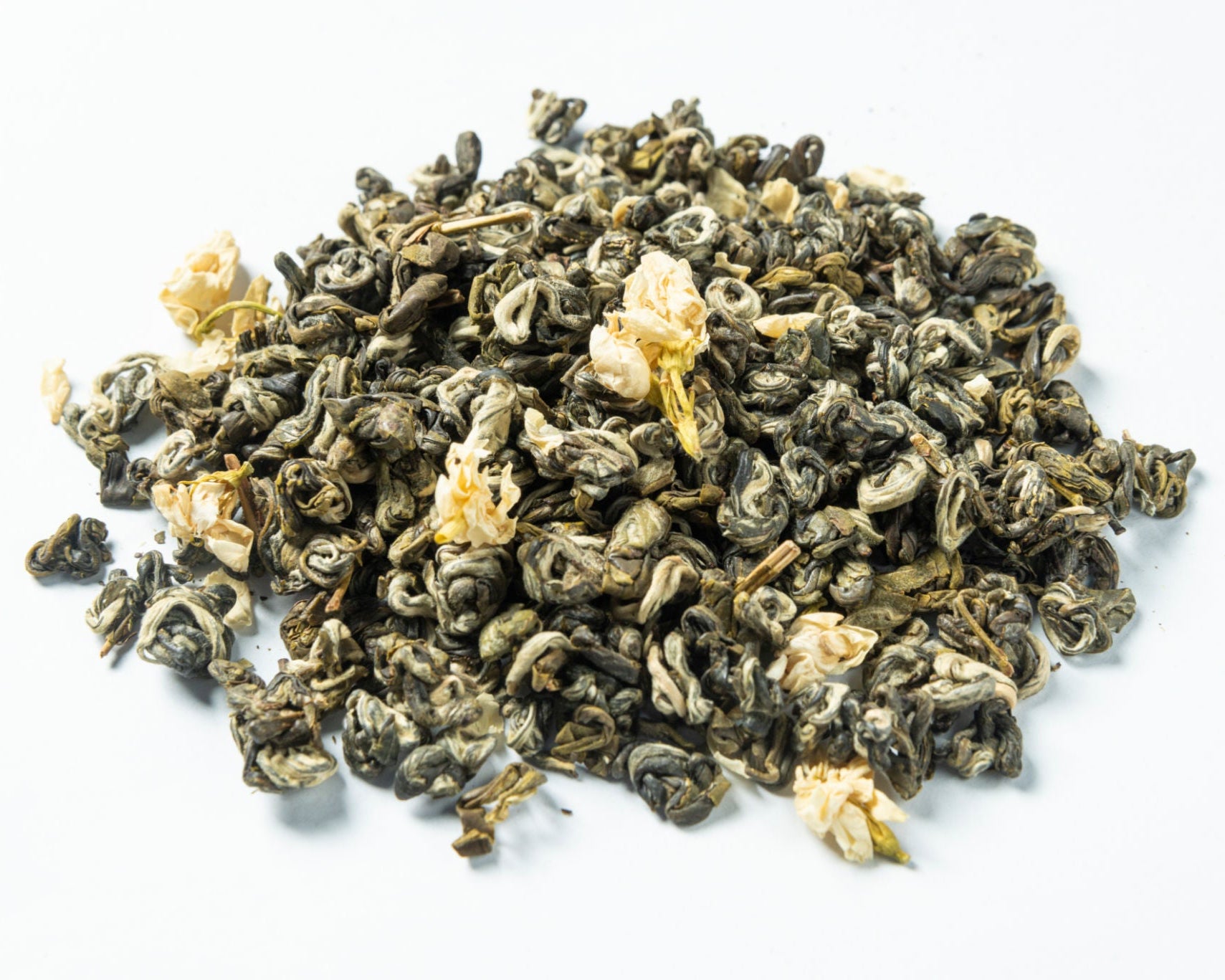 Dry green tea leaves on a white background